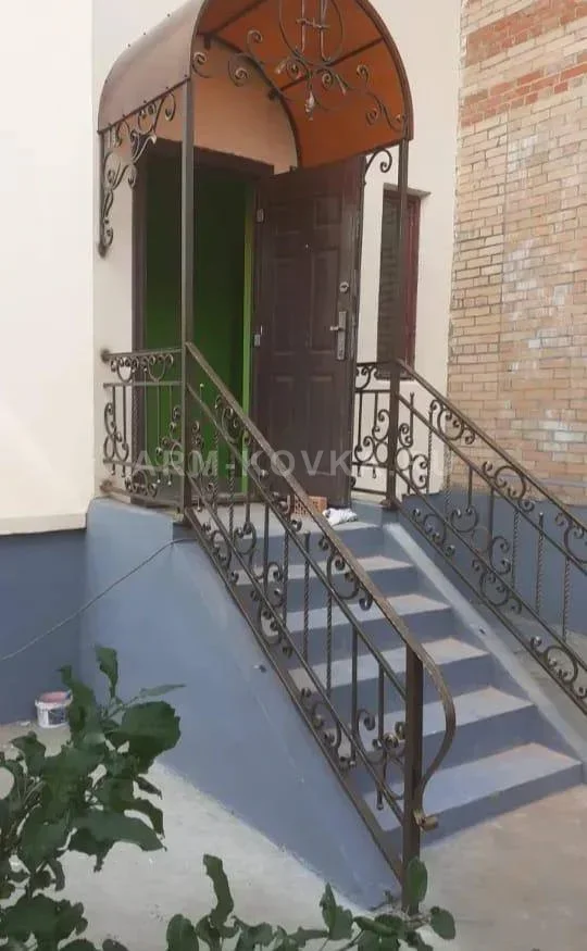 Арочный козырек с коваными украшениями и перилами на лестницу